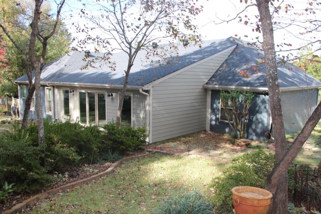 Patio conversion to a full sunroom, light grey James Hardie siding and Marvin Windows on the backside of a deep blue home